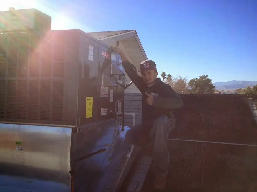 HVAC technician performing Heat Pump Repair on a rooftop unit in Tarboro